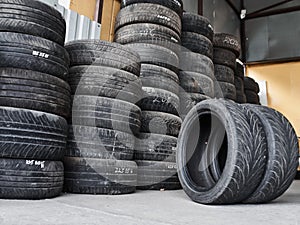 Used car tires stacked in piles at tire fitting service. Wheels for repair shop. Car service concepr