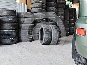 Used car tires stacked in piles at tire fitting service. Wheels for repair shop. Car service concepr