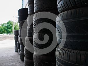 Used car tires stacked in piles at tire fitting service. Wheels for repair shop. Car service concepr