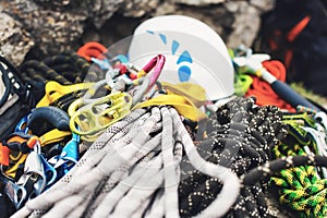 Used climbing equipment - carabiner without scratches, climbing hammer, white helmet and grey,red,green and black rope