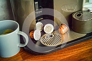 used coffee capsules abandoned near the slot for removable drip tray