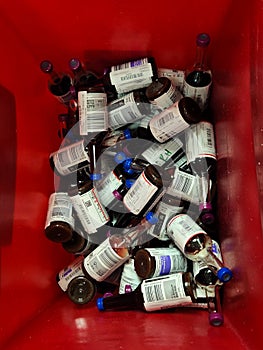 Used, contaminated blood culture bottles inside red waste container