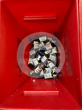 Used, contaminated blood culture bottles inside red waste container