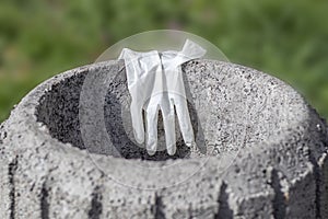 Used disposable glove on a garbage container close up