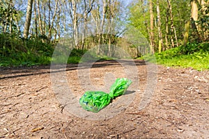 Used dog poo bag discarded by irresponsible dog owner on public footpath. Hertfordshire. UK