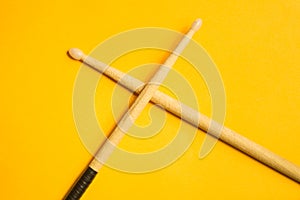 Used drumsticks isolated on yellow background. copy space