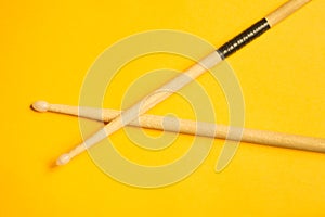 Used drumsticks isolated on yellow background. copy space