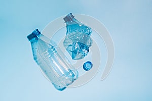 Used empty crumpled plastic bottles on blue background. Recycling recycled plastic. Pollution, environmental protection.