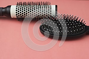 Used Hair brush tools on pink or coral background with copy space. Beauty fashion, hair care background