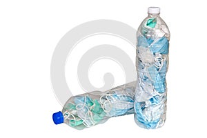 Used masks are stored in plastic water bottles to be disposed of in the trash to prevent the spread of COVID-19 isolated on white