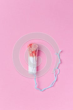Used medical female tampon over a pink background. Menstruation, means of protection