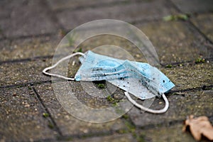 Used medical mask on street ground