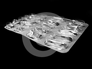 Used medication packaging on black background