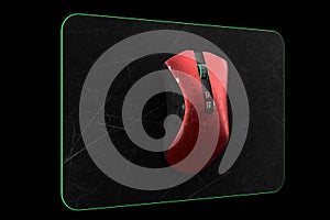 Used metal red gaming mouse with scratches on professional pad isolated on black