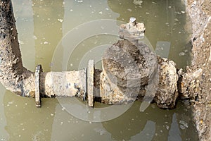 Used muddy water pipe valve in a trench