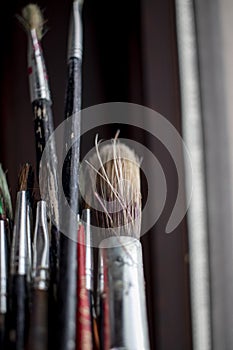 Used oil paint brushes illuminated by daylight filtering through the window. close up.