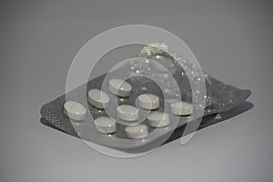 Used packs of pills on white medical table. It is isolated on white background. Used medicine tablets strip