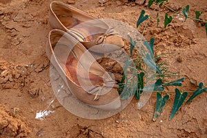 Used pair of shoes on bare soil