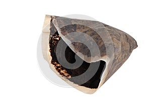 Used paper filter filled with coffee grounds closeup on white background