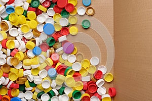 Used PET recycling plastic bottle cap plastic lids. Colorful bottle caps background cardboard box. Garbage PET waste