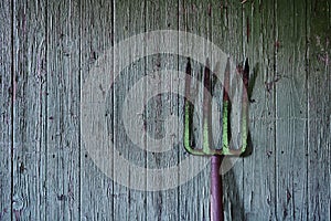 Used pitchfork and weathered barn