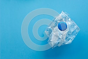 Used plastic bottles crushed and crumpled against on the blue background