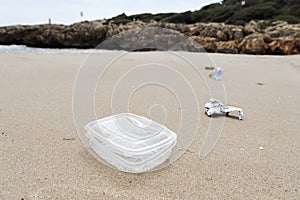 Used plastic container thrown on the beach