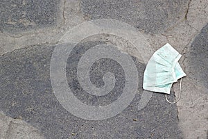 Used protection mask thrown on the street floor, sanitary and environmental pollution