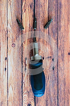 Used screwdriver heads on wooden background