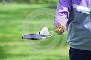 used shuttlecock in badminton racket holding by a man in the park