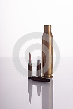 used spent shells of cartridges from a machine gun and a machine gun on a white background