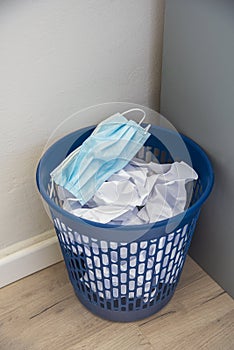 Used surgical face mask in a blue bin. The masks used during the Corona Covid-19 virus epidemic were thrown away.