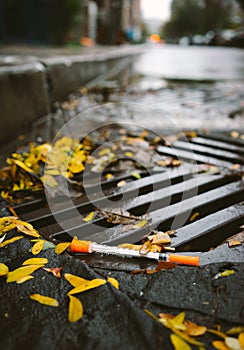 A used syringe discarded in a gutter