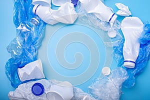 Used unsorted clean garbage in a pile. Bottles, bags and paper on blue background. Waste sorting. Place for text