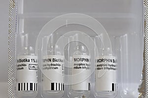 Used vials of injectable solution Morphine  in a box. Morphine is strong painkiller and reduces the perception of dyspnea