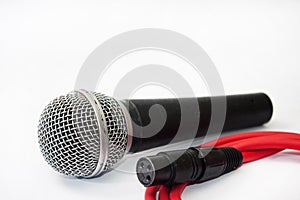 Used vocal microphone with red xlr cable on the white background