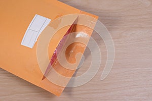 Used yellow blank envelope with transparent bubble wrap or packaging shockproof on wooden table.