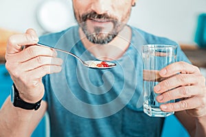 Useful colorful pills lying in the spoon.