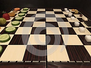 Useful and harmful foods play chess. Junk foods vs Vegetables
