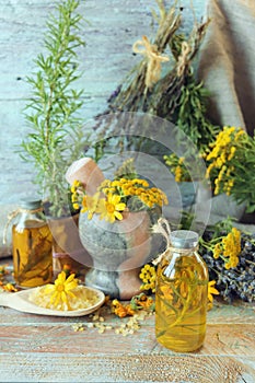 Useful plants, oils and tinctures, lavender flowers, calendula, tansy and rosemary, on a wooden background