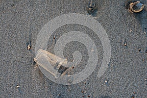 Useless plastic glass on the beach