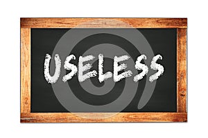 USELESS text written on wooden frame school blackboard