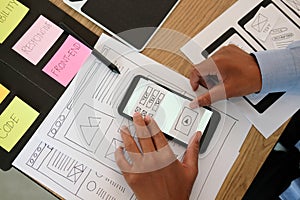 User experience UX designer designing web on smart phone layout. UI developer planning working on mobile application prototype