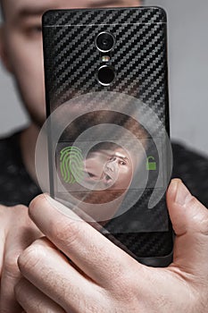 The user scans the finger to pass the biometric protection of the phone. the concept of face ID