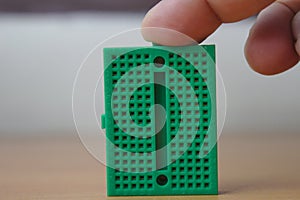 A user tapping a green protoboard vertically