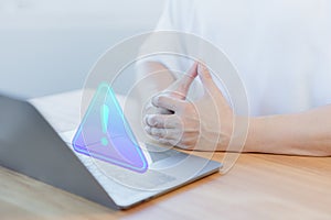 User use a computer laptop with caution warning sign for notification error.