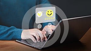 User use a laptop give point with virtual screen on smile face icon for satisfaction in opinion and service.