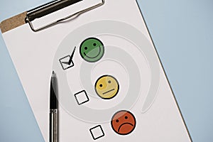 User use pen to check mark select smile face for customer evaluation survey after client use product and service , Customer