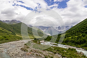 Ushguli- Patara Enguri River flowing down the valley in the Greater Caucasus Mountain Range in Georgia. Flowers