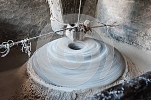 Using an Ancient Manual Stone Mill. Flour machine in use. Close up of stone or grinder or old motor or pestle or grain mills on ro